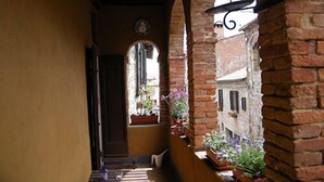 A narrow corridor with brick walls and wooden beams, leading to a door at the end. - B&B Il Glicine Residenza D'Epoca (Torrita di Siena)