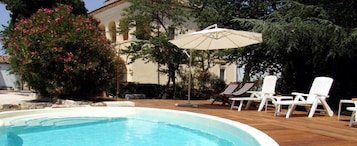 Una piscina con sillas de descanso y una sombrilla.