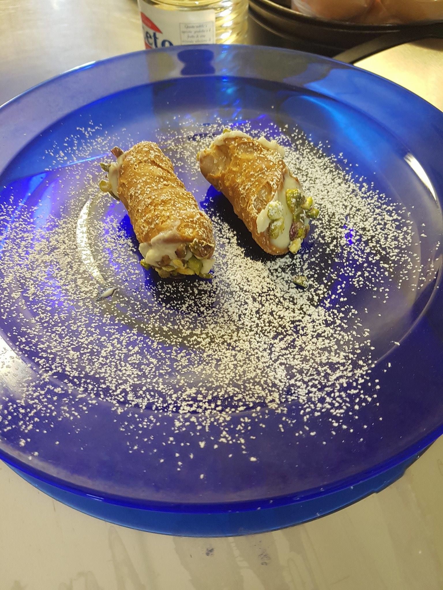 A blue plate with two pastries dusted with powdered sugar.