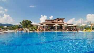 Una piscina al aire libre de temporada, sombrillas