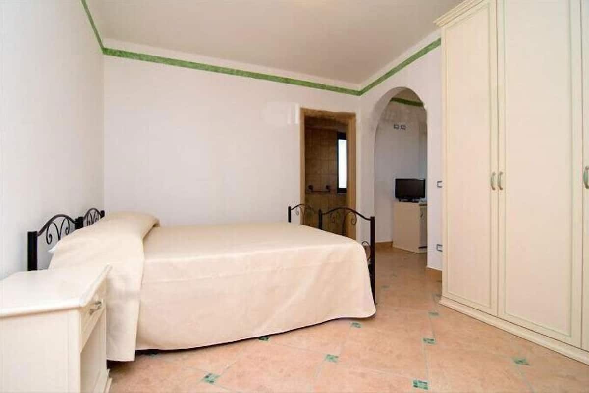 A bedroom with a bed, a wardrobe, and a desk.