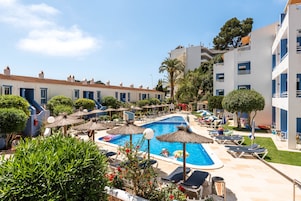 Una piscina al aire libre de temporada, sombrillas, tumbonas
