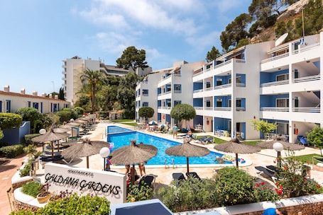 Una piscina al aire libre de temporada, sombrillas