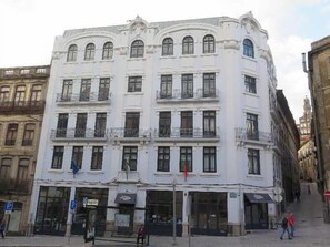 A multi-story building with a classic architectural style, featuring balconies and large windows.