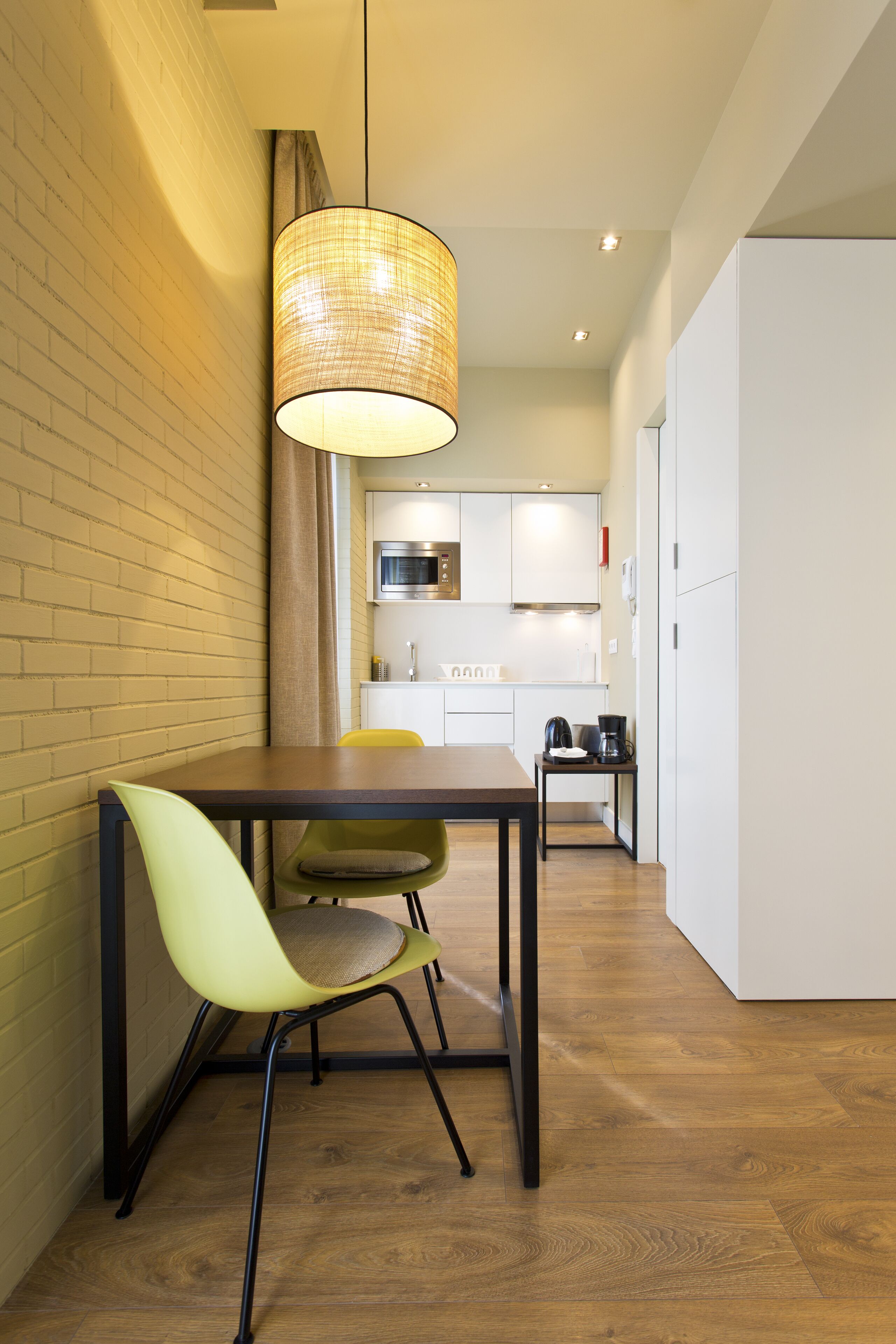 A modern kitchen with white cabinets, a microwave, and a coffee maker on the counter.