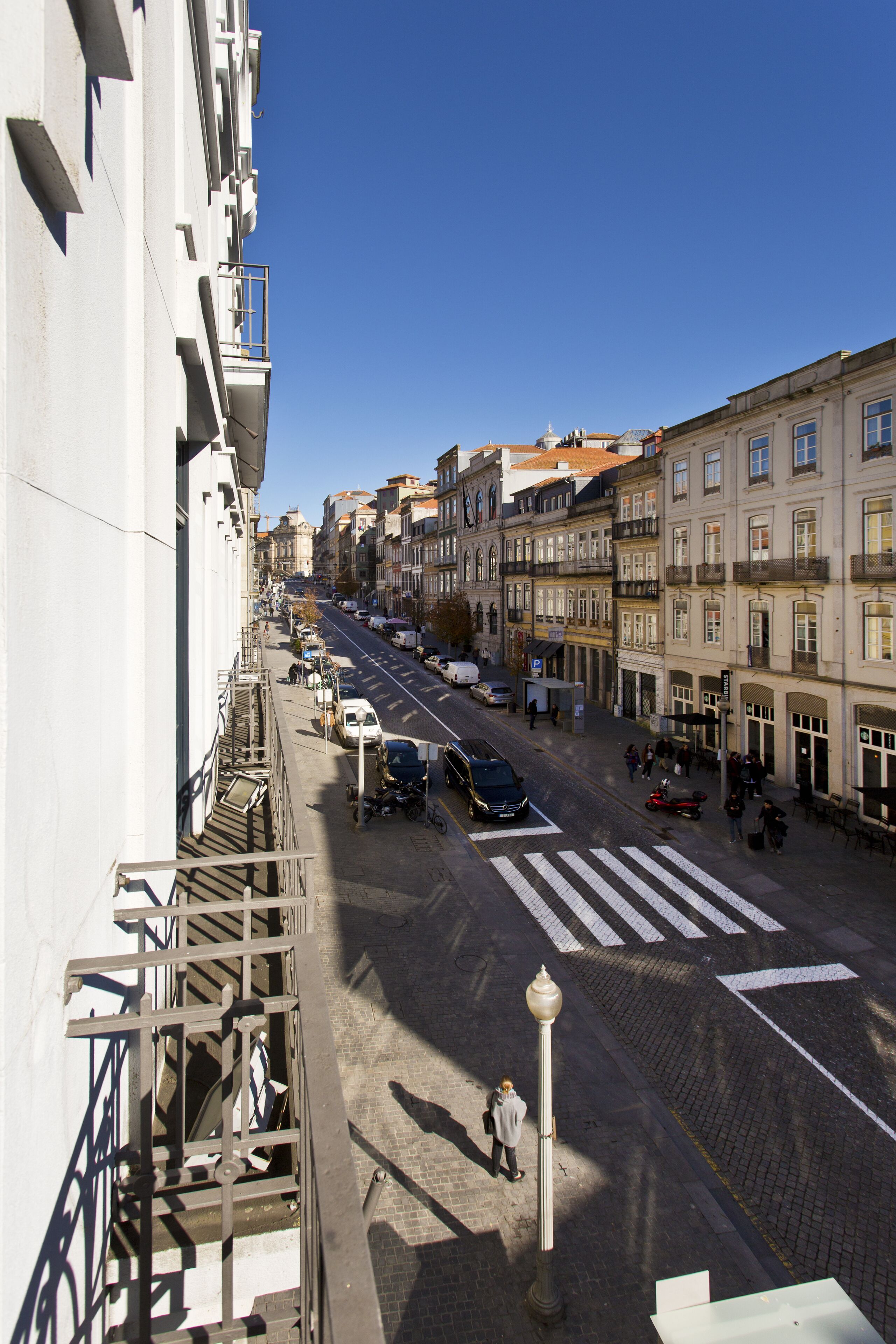 A street view with buildings, a crosswalk, and a few pedestrians.