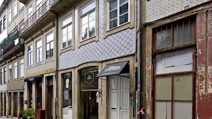 A row of buildings with various storefronts, including a vintage clothing store. - RVA Porto Central Flats (Porto)