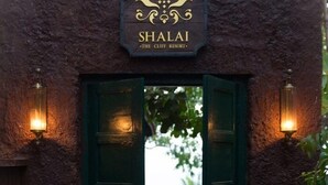 Un ingresso rustico con un cartello che riporta la scritta "Shalai The Cliff Resort".