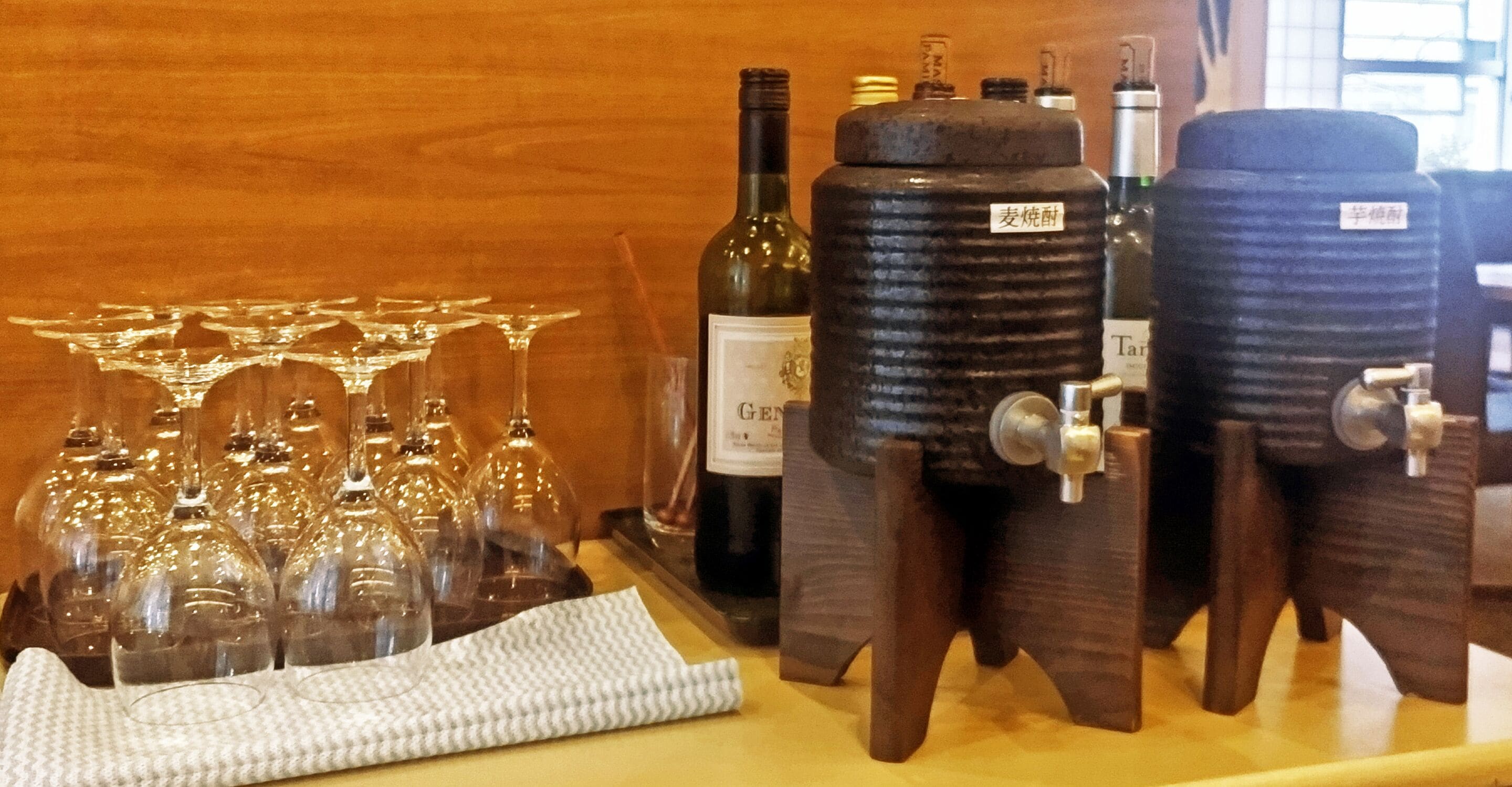 A wine dispensing station with multiple bottles and glasses.