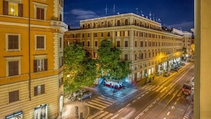A historic building with classical architecture, a pedestrian crossing, and a street with vehicles. - Amalia Suites (Rome)