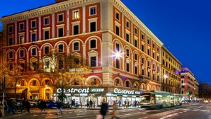A historic building with multiple stories, featuring arched windows and a prominent entrance. - Amalia Suites (Rome)