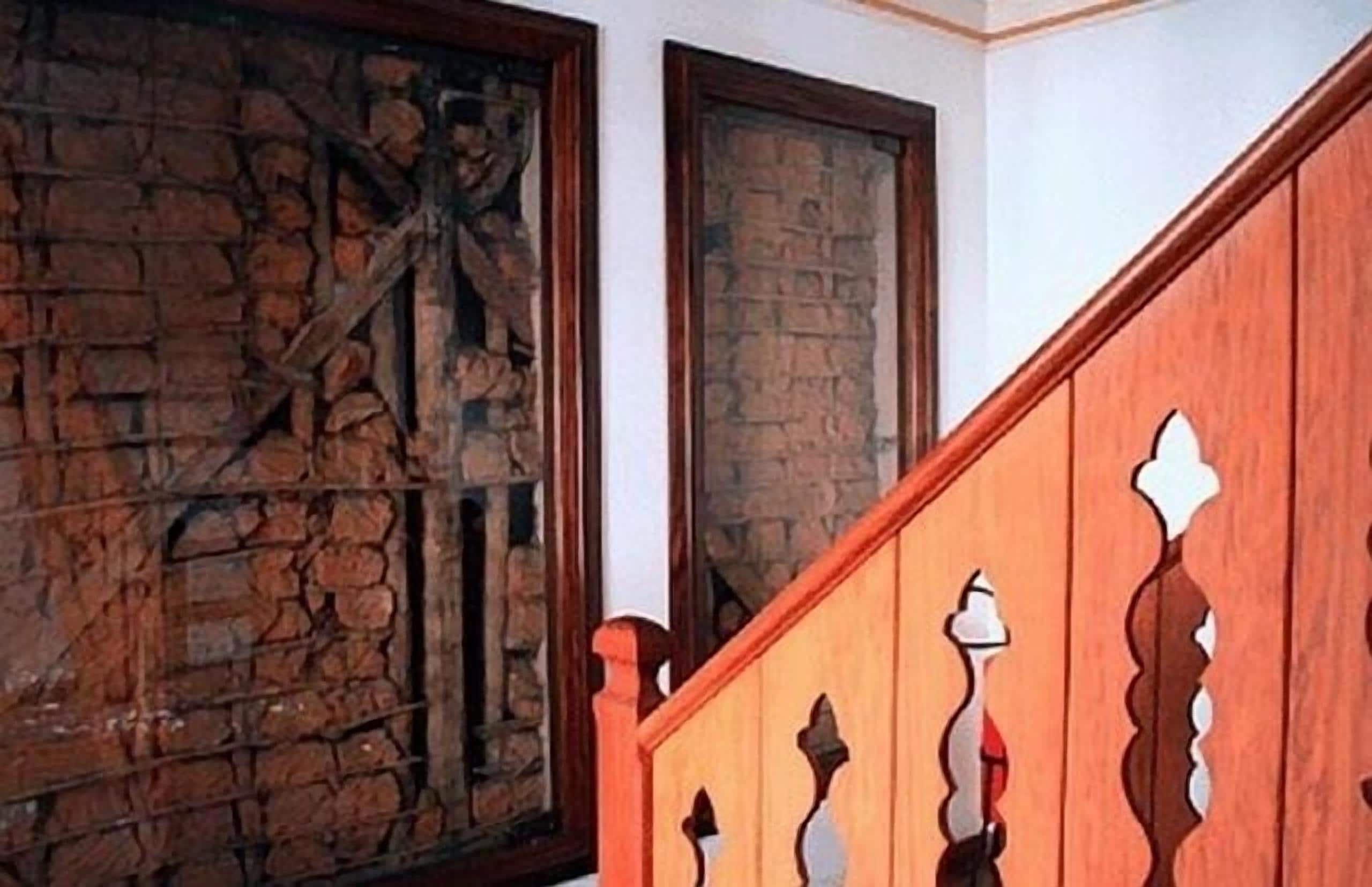 A staircase with wooden railings and a stone wall.