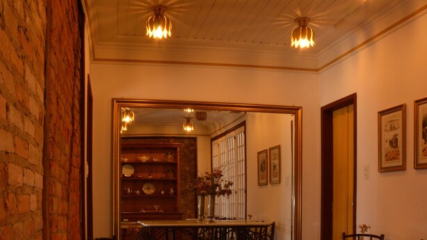 Comedor con mesas redondas, sillas y pared de ladrillo.