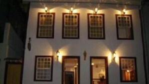 Un edificio con varias ventanas y puertas, algunas con luces encima.