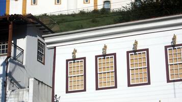 Ein weißes Gebäude mit einem Glockenturm, zahlreichen Fenstern und einer Tür.