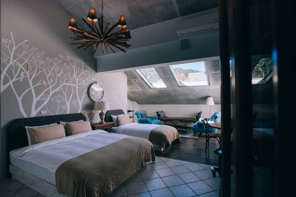 A bedroom with two beds, a skylight, and a view of the outdoors.