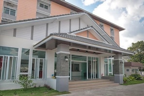 A modern two-story house with a covered porch, large windows, and a well-maintained lawn.