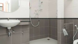 Une salle de bain moderne équipée d’un lavabo, d’une douche et de toilettes.