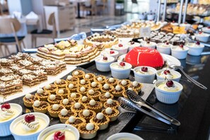 A buffet table with various desserts including cakes, tarts, and cream-based dishes. - Sentido Hotel Neptun Beach - All inclusive (Sunny Beach)