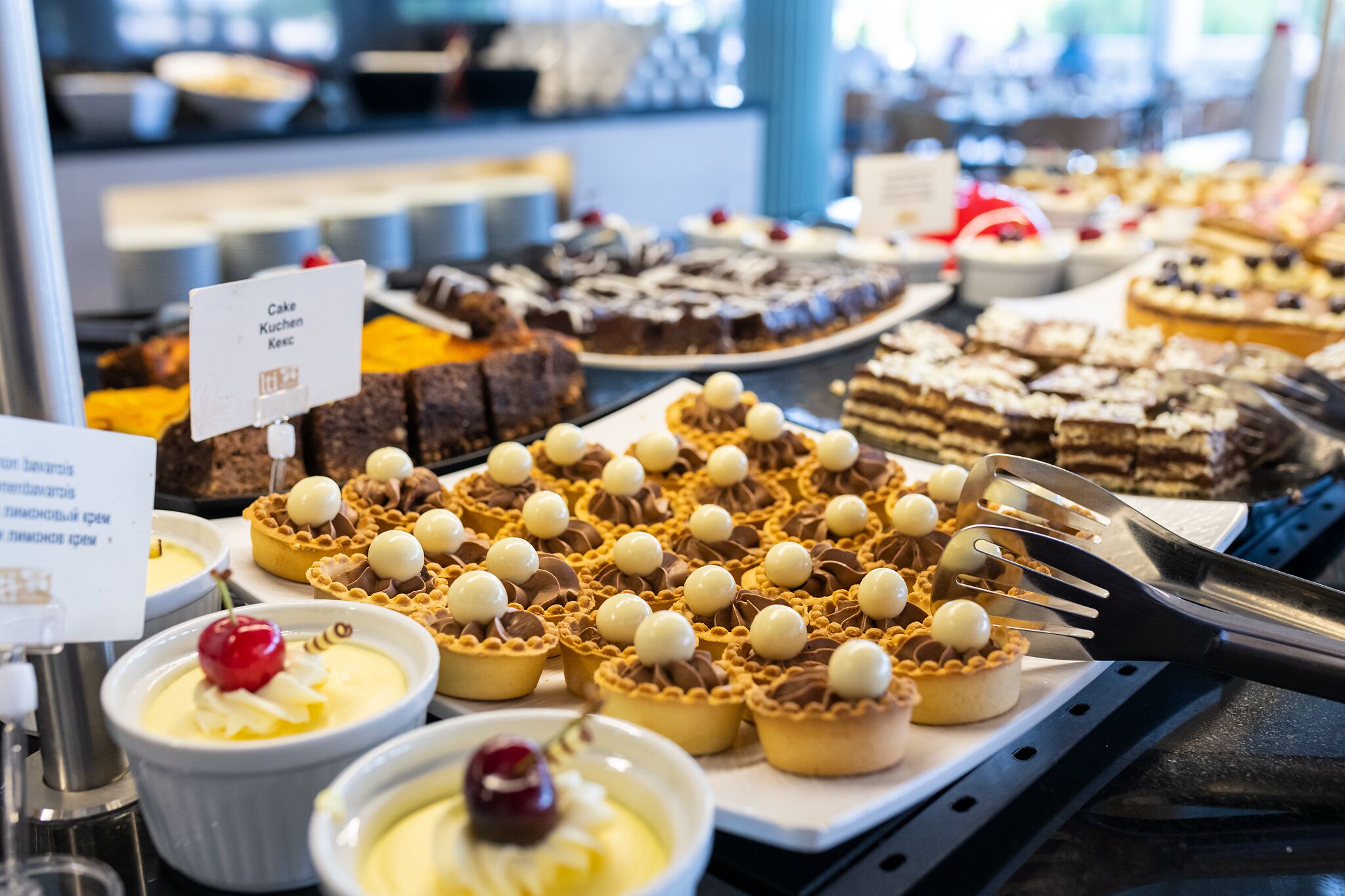 A variety of desserts on display, including cakes and tarts, with a sign indicating a price of 10.