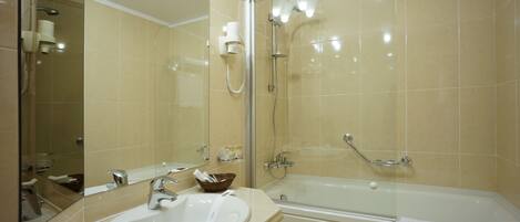 A bathroom with a sink, mirror, and bathtub.