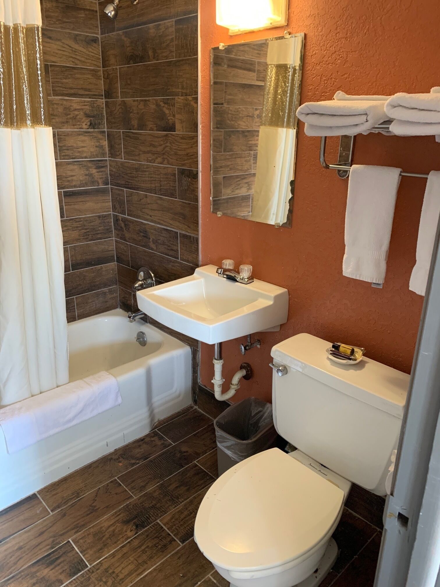 A bathroom with a bathtub, sink, toilet, and a mirror.