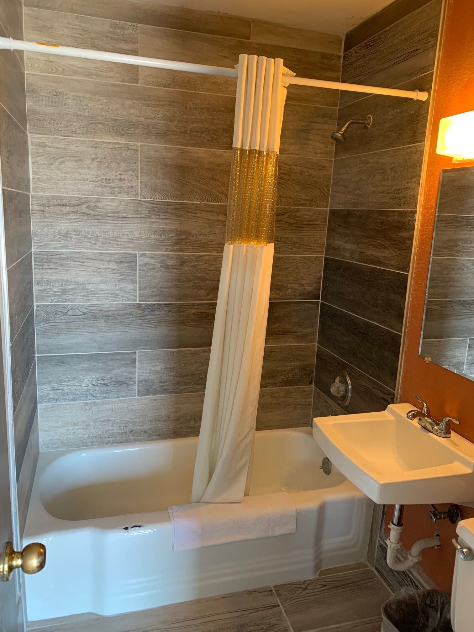 Un bany amb banyera, cortina de dutxa i un lavabo.