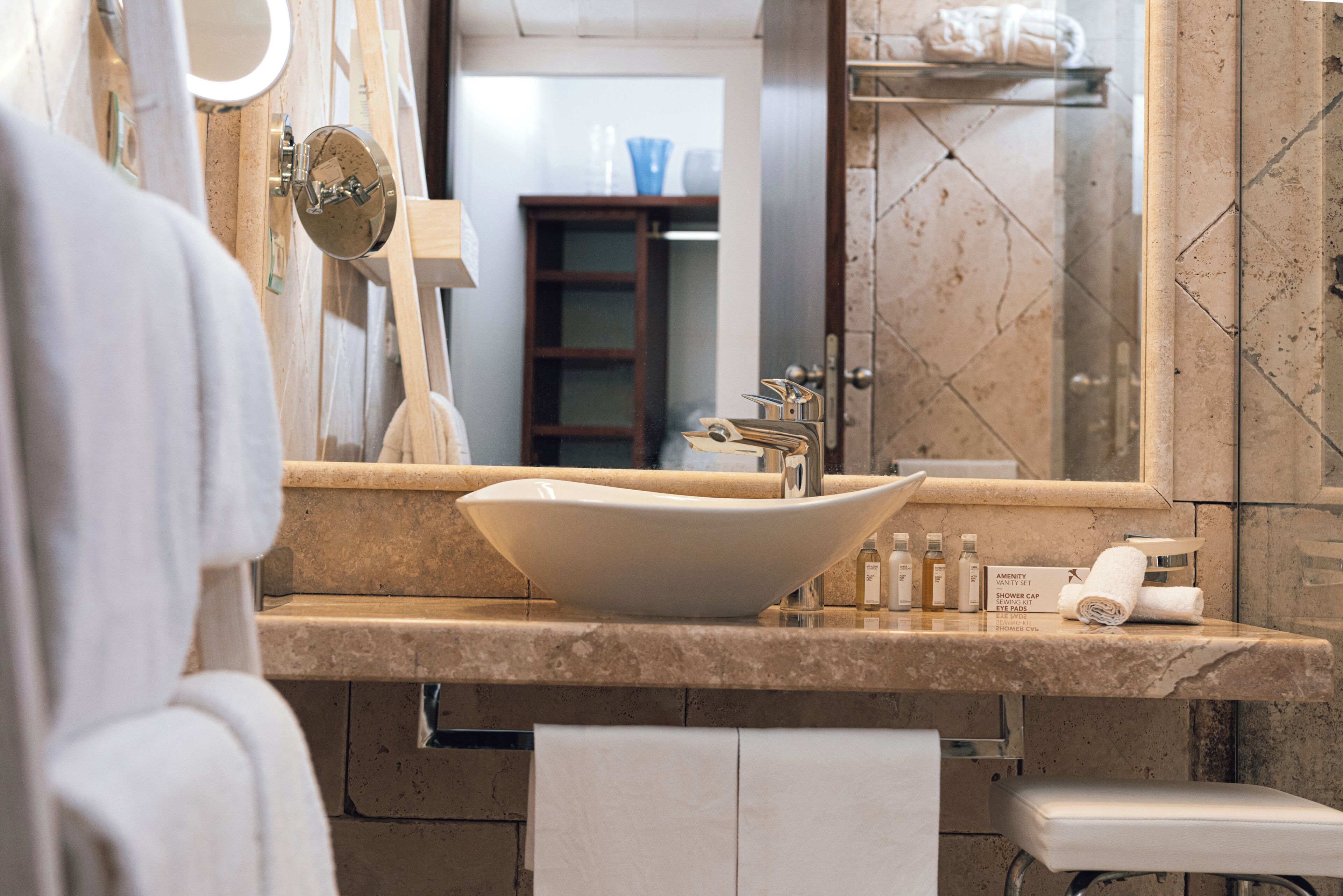 A bathroom with a large sink, mirror, and towel rack.