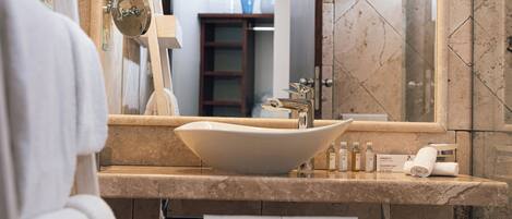 A bathroom with a large sink, mirror, and towel rack.