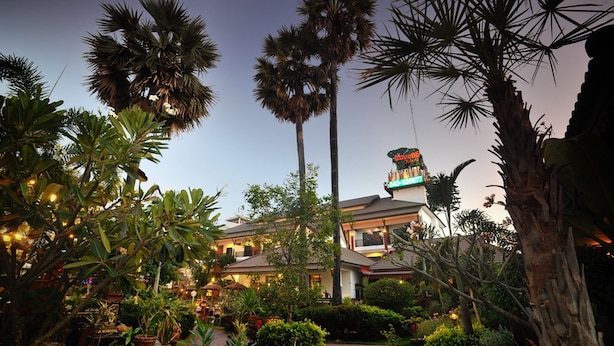 A hotel with a garden, palm trees, and a sign with a green roof. - Mammoth Resort (Khon Kaen)