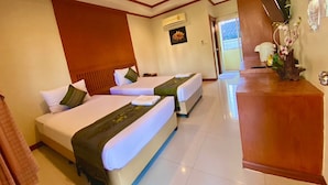 A hotel room with two beds, a wooden reception desk, and a wall-mounted air conditioning unit. - Mammoth Resort (Khon Kaen)