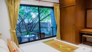 A hotel room with a large window, a bed, a small table, and a wardrobe. - Mammoth Resort (Khon Kaen)