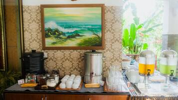 A coffee station with a painting of a landscape, a clock, and a sign reading "Gaiamblaw Coffee".