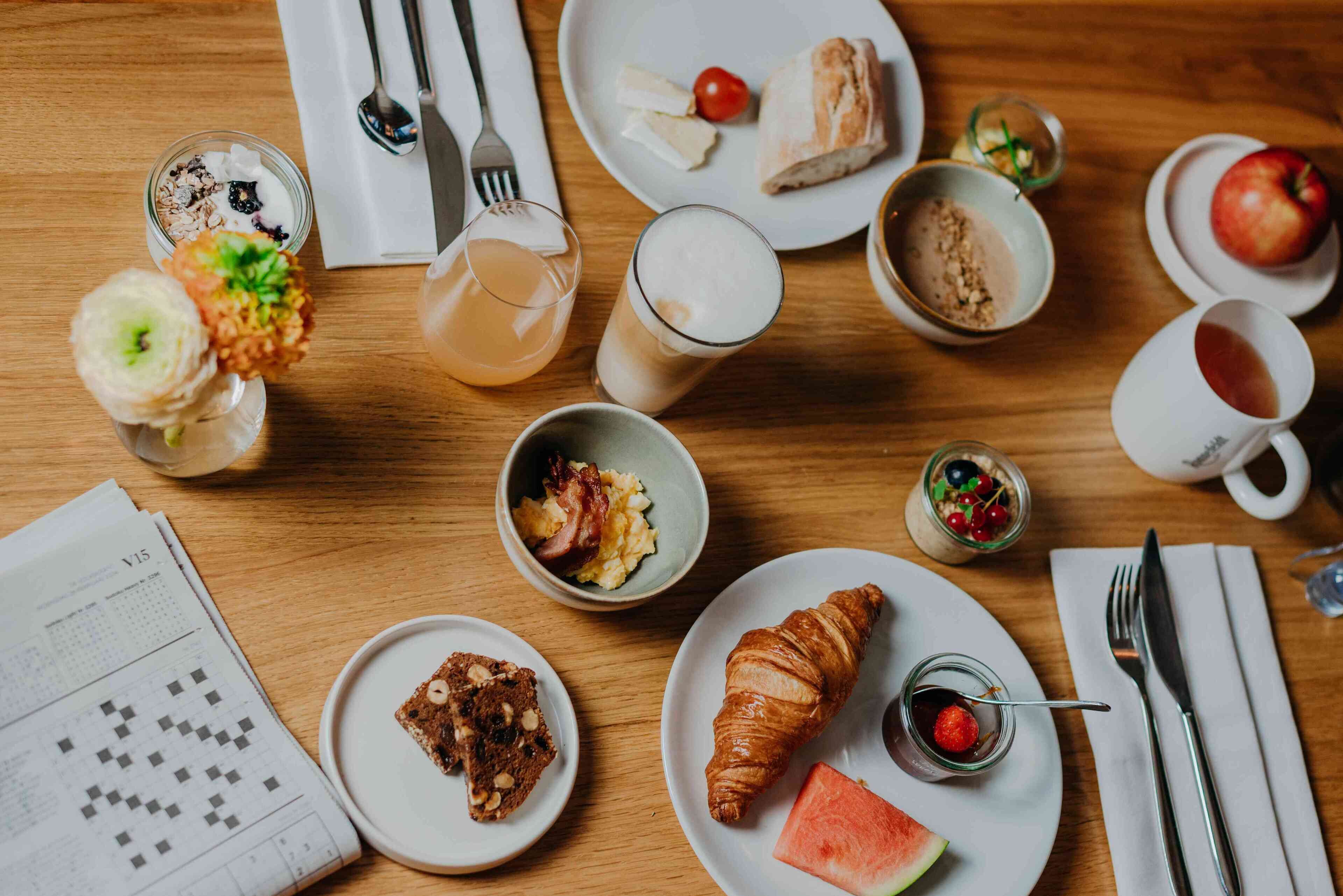 Una mesa de madera con diferentes alimentos y bebidas para el desayuno.