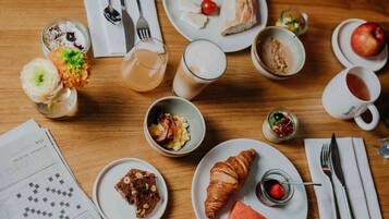 Una mesa de madera con diferentes alimentos y bebidas para el desayuno.