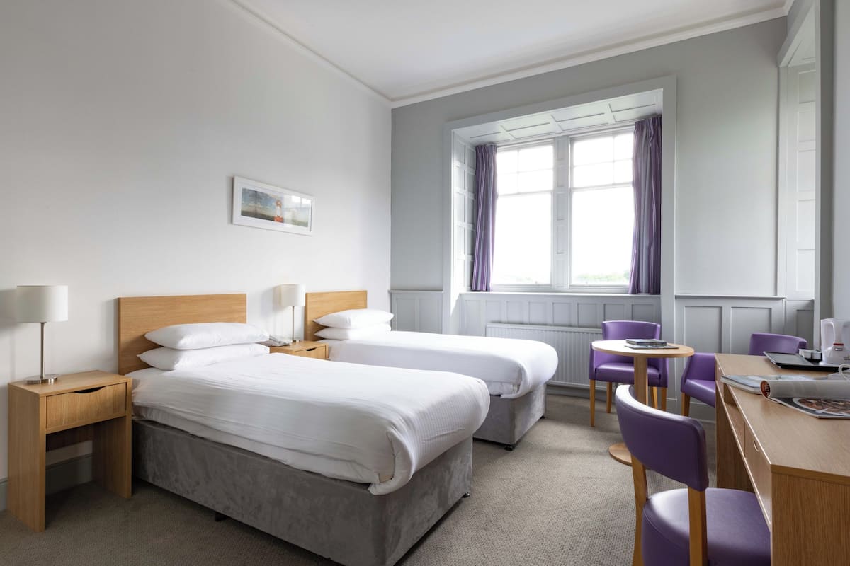 Escrivaninha, ferros/tábuas de passar roupa, roupa de cama