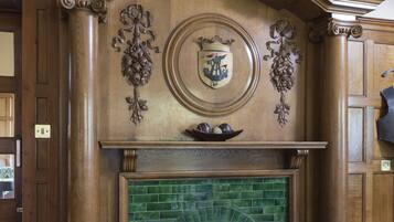 A fireplace with a green tiled surround and a plaid mantle.