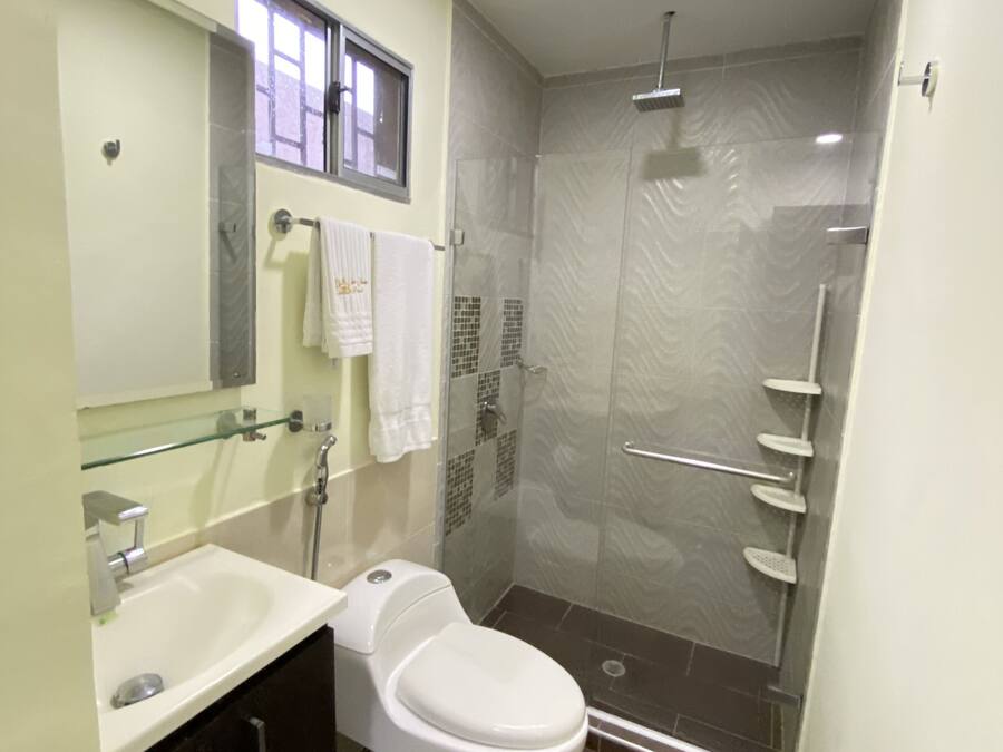 A modern bathroom with a toilet, sink, and shower.