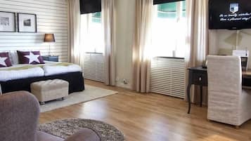 Una habitación de hotel moderna con una cama, un escritorio, una silla y un televisor.
