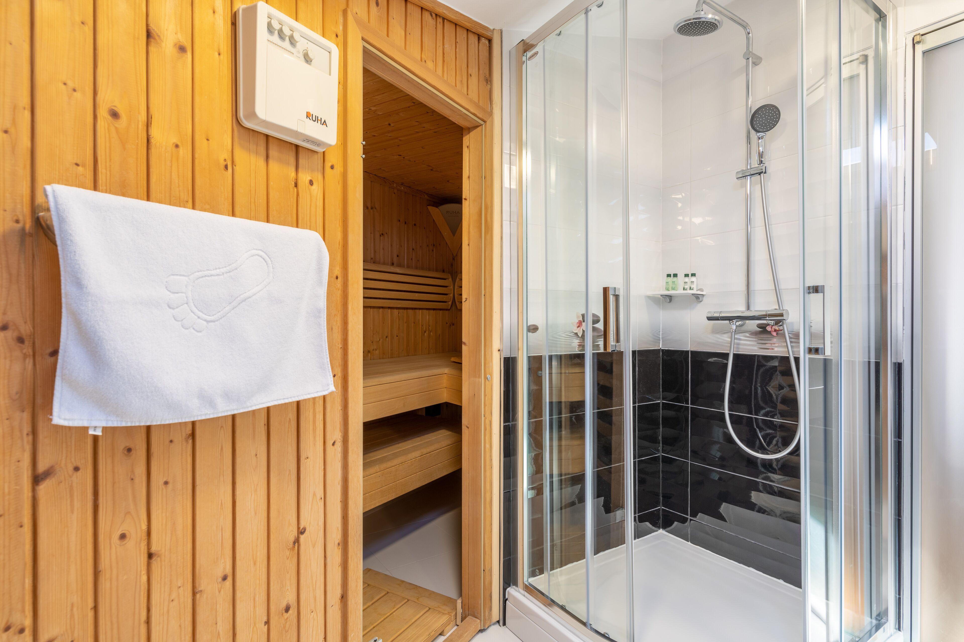 A wooden sauna room with a glass shower enclosure.
