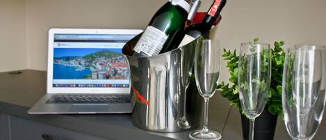 Ein Laptop auf einem Schreibtisch zusammen mit einer Champagnerflasche und Gläsern.