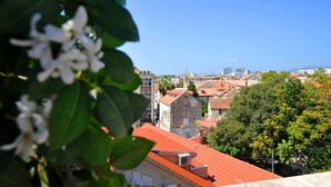 A view of a cityscape with traditional buildings and a red-roofed structure in the foreground. - Nirvana Luxury Rooms (Split)