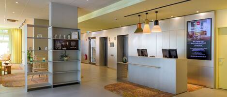 A reception area with a desk, chairs, a display board, and a fire extinguisher.