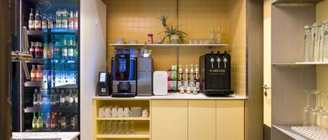 A bar area with a refrigerated drink dispenser, a coffee machine, and a water dispenser.