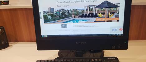 A Lenovo monitor displaying a webpage for IHG Rewards Club with a poolside view.