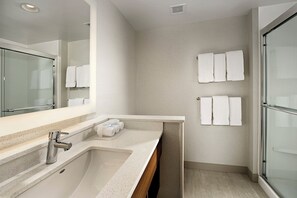 A modern bathroom with a large mirror, a sink, and a shower area. - Holiday Inn Express & Suites Altoona by IHG (Altoona)