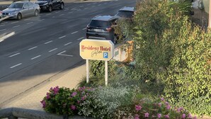 Vista de la calle con un letrero de 'Residenz Hotel Gießen' que indica un área de estacionamiento.