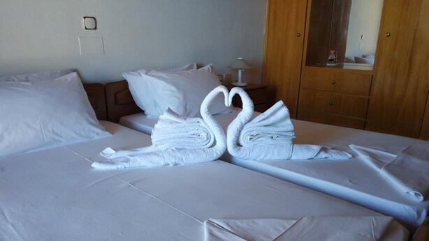 Un llit ben fet amb llençols blancs i dues tovelloles amb forma de cigne.