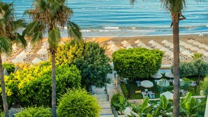 A resort with a view of the ocean, palm trees, and a well-maintained garden with pathways and seating areas. - Melas Resort Hotel (Manavgat)