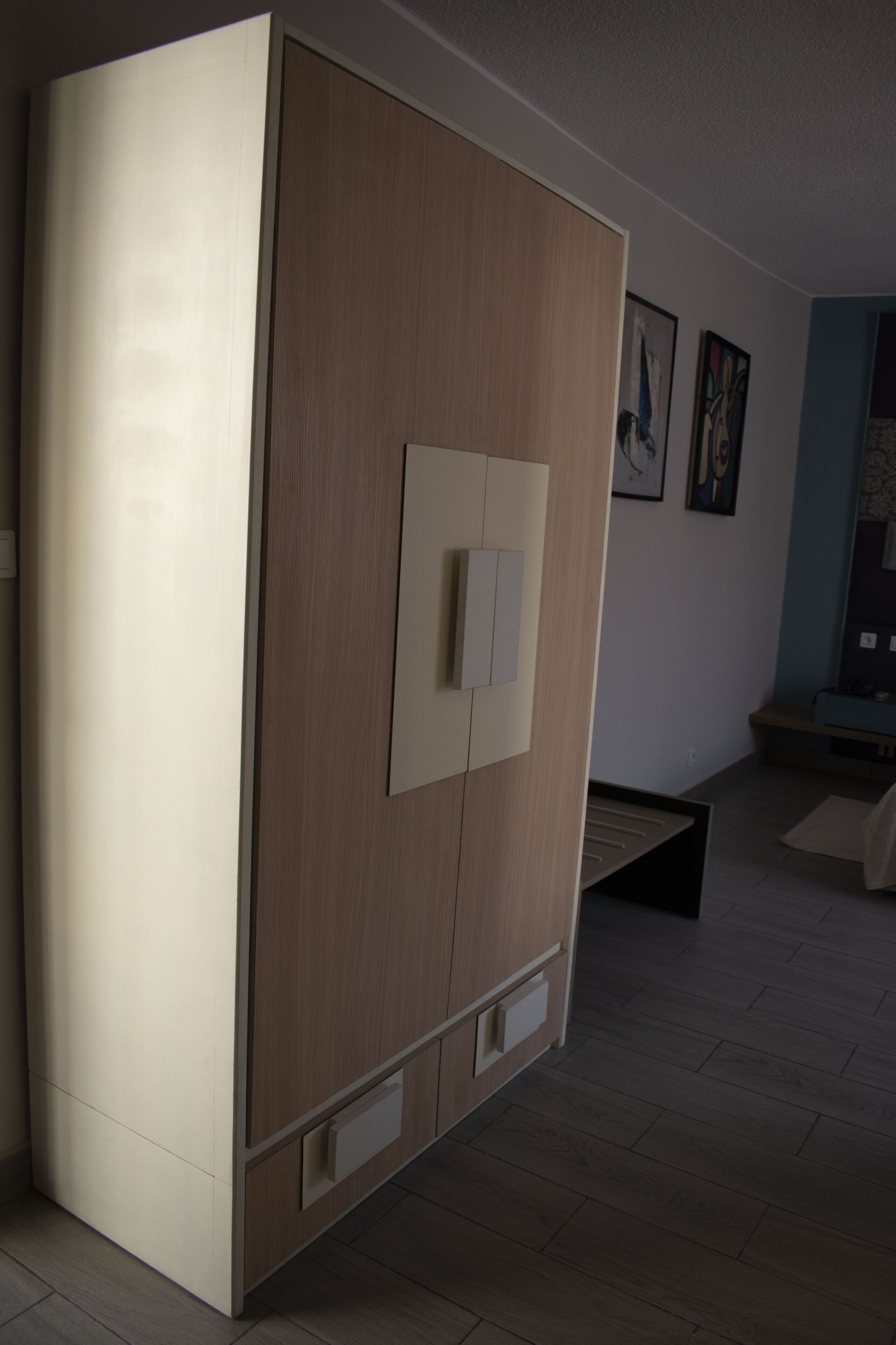 Una habitación moderna con un armario grande, un banco y una obra de arte en la pared.